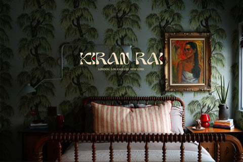 Decorative room with a bed, wall art, and 'Kirab Rai' branding, London, Los Angeles, New York.